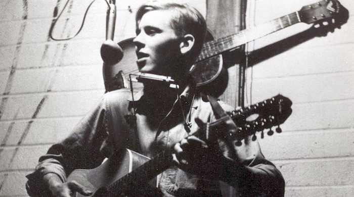 Stephen Rusch playing guitar, singing, and playing harmonica. Circa 1960s